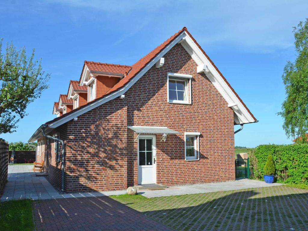 a red brick house with a white door at Ferienhaus Lobbe F 544 WG 02 über zwei Etagen, strandnah in Lobbe