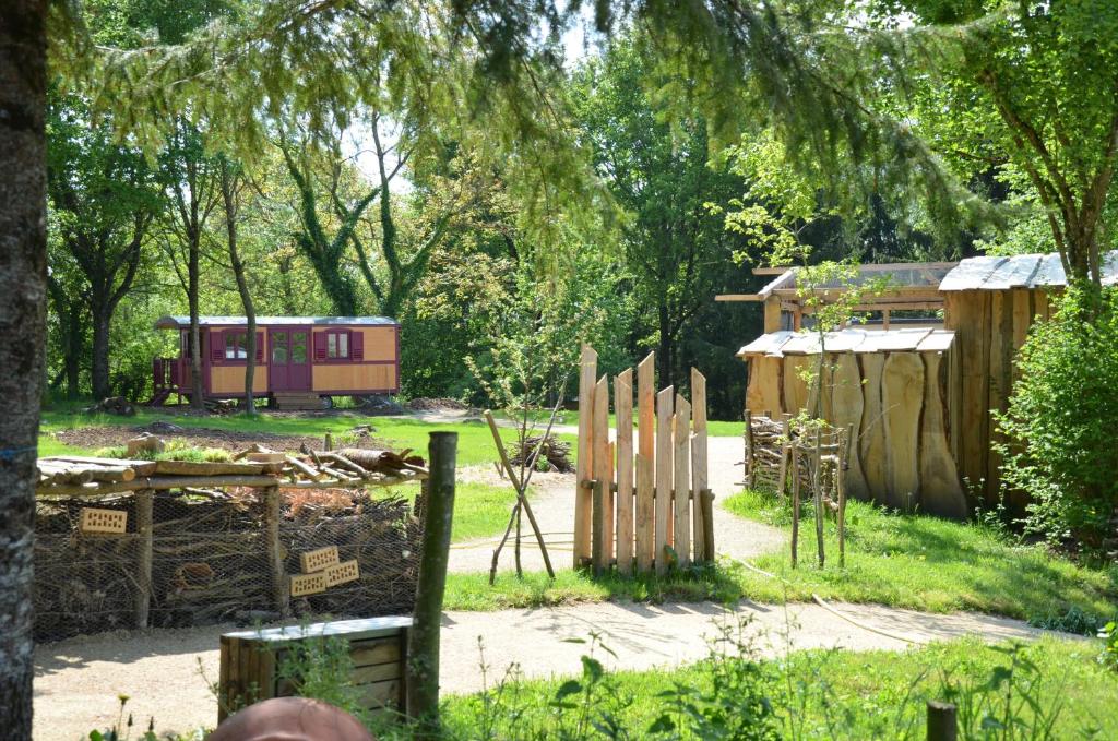 een tuin met een houten hek en een huis bij Le camp du fauconnier in La Pommeraie-sur-Sèvre
