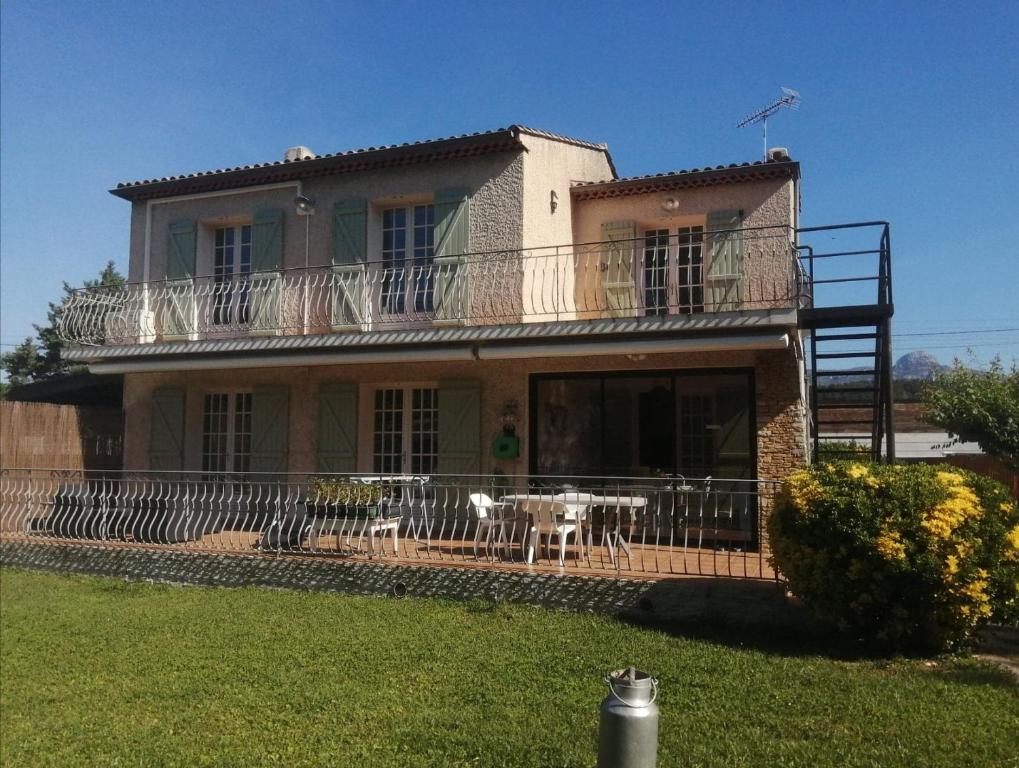 a large house with a balcony and a table at GITE HISTOIRE DE FAMILLE in Aubagne