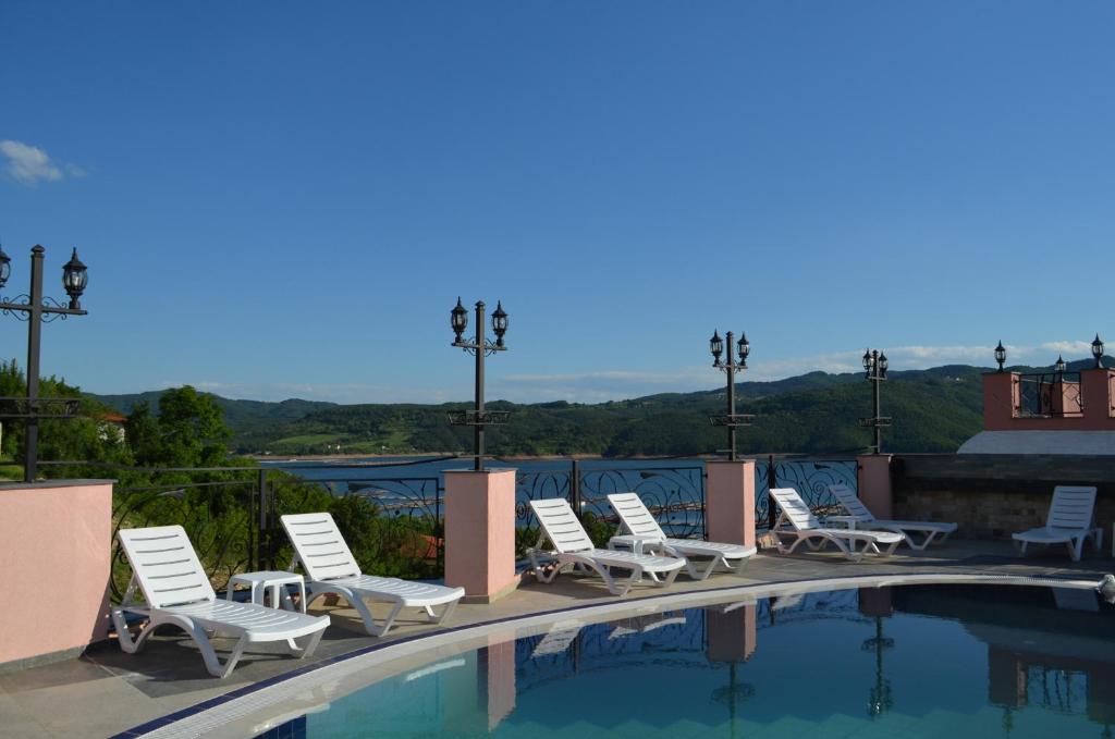 - un groupe de chaises assises autour d'une piscine dans l'établissement MOBI DICK Family Hotel, à Glavatartsi