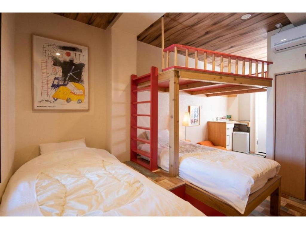 een slaapkamer met 2 bedden en een stapelbed bij BEYOND HOTEL Takayama 2nd - Vacation STAY 82239 in Takayama