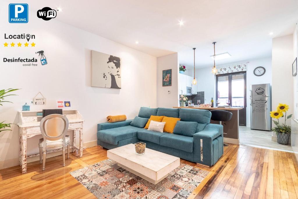 a living room with a blue couch and a kitchen at Apartment between Old Town & Guggenheim!! Private Parking in Bilbao