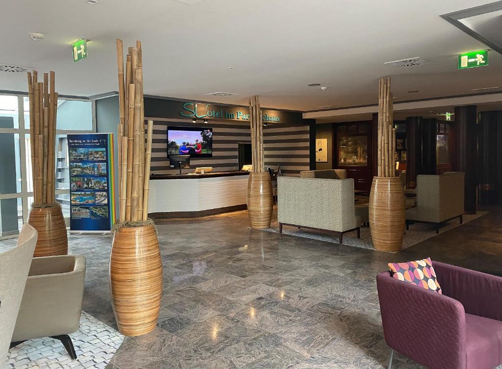a lobby with chairs and a bar with a tv at SL'otel im Parforcehaus in Bernburg