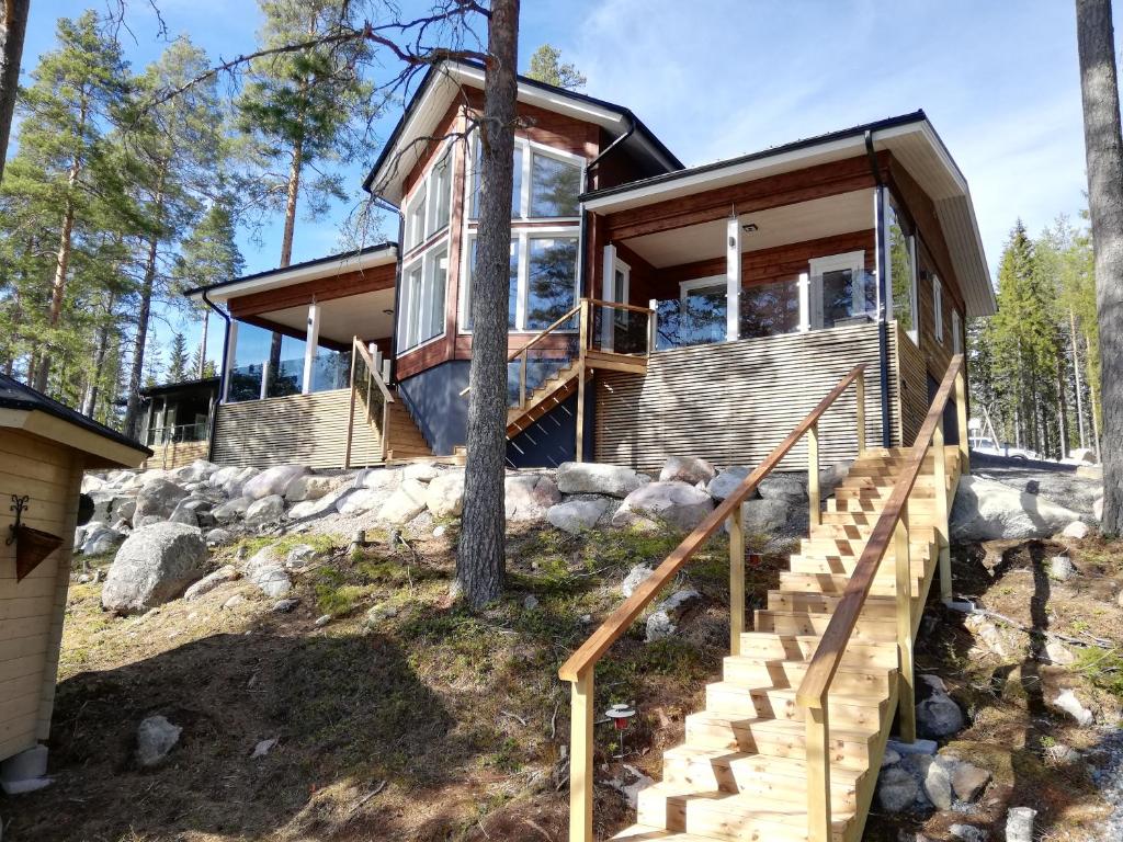 a house in the woods with a staircase leading up to it at Ulpukkaranta in Ähtäri