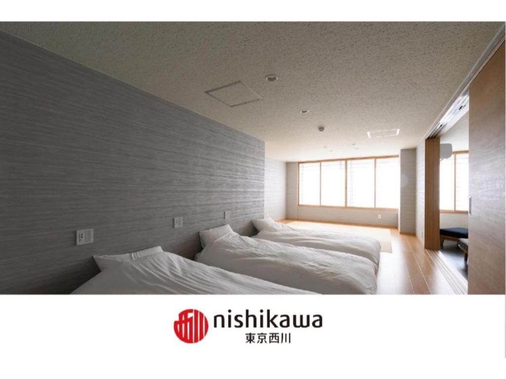 1 dormitorio con 2 camas y pared en BEYOND HOTEL Takayama 3rd - Vacation STAY 82217 en Takayama