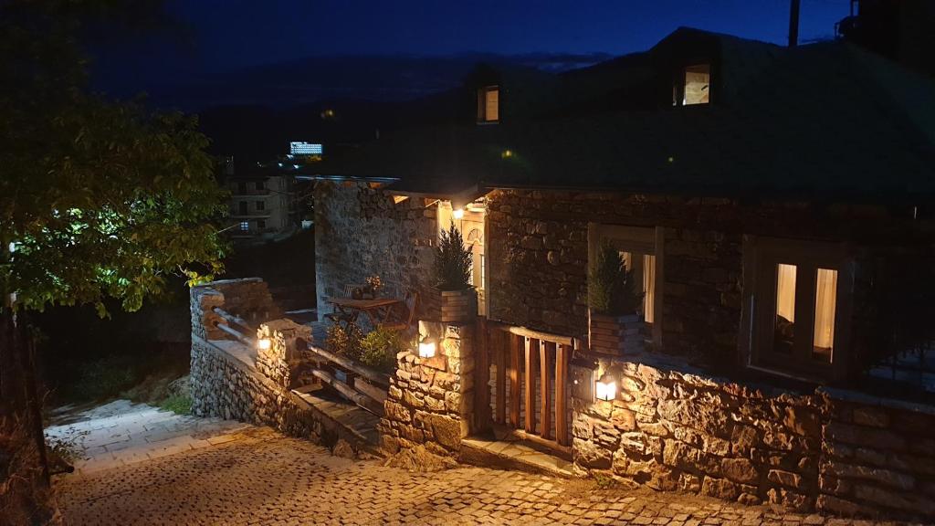 ein Steinhaus in der Nacht mit Lichtern in der Unterkunft The House in the Cobbled Road in Karpenisi