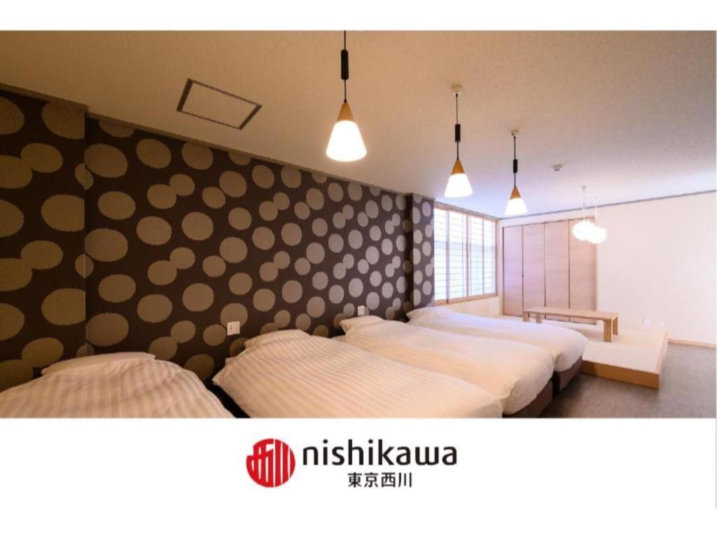 two beds in a bedroom with polka dots on the wall at BEYOND HOTEL Takayama 3rd - Vacation STAY 82215 in Takayama