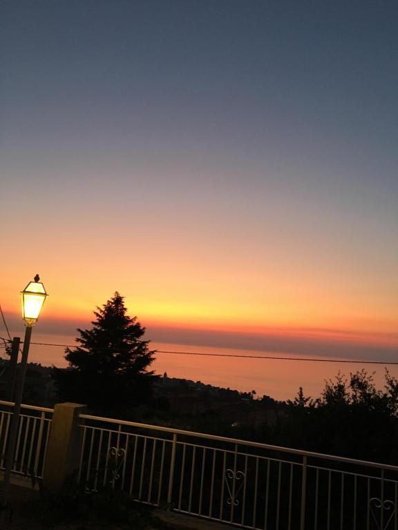 um pôr-do-sol sobre a água com uma luz de rua em Balconcino degli innamorati Tropea em Santa Domenica