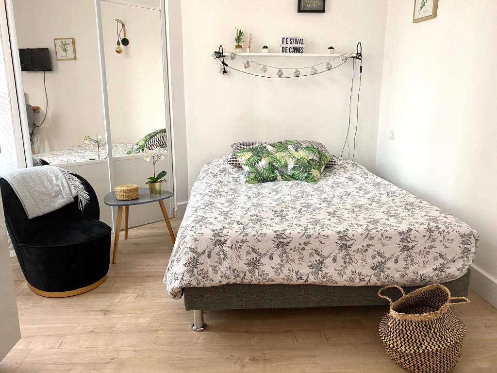 une chambre avec un lit, une chaise et un miroir dans l'établissement Charmant studio proche Palais des festivals - Marché Forville, à Cannes