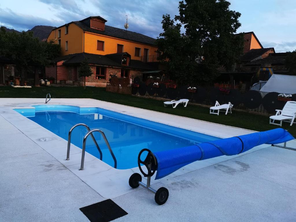 ein blauer Swimmingpool mit einem Spielzeug vor einem Haus in der Unterkunft Cornatel Médulas in Borrenes