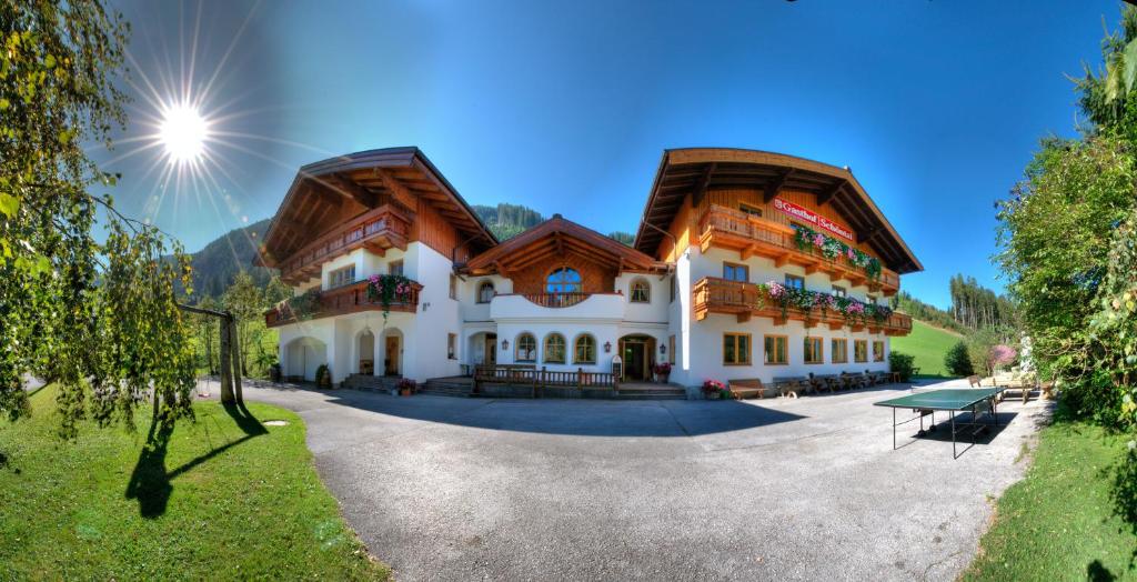 ein großes Gebäude mit einem Holzdach in der Unterkunft Gasthof Schöntal in Werfenweng