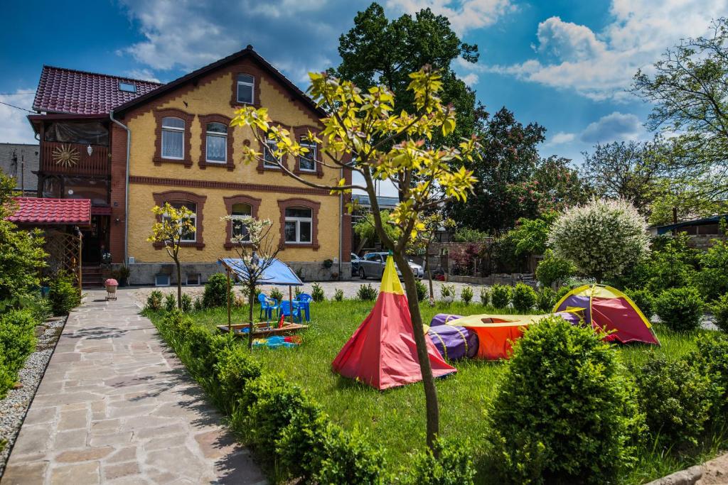 un jardin avec des tentes en face d'une maison dans l'établissement Noclegi na Polnej, à Bolesławiec