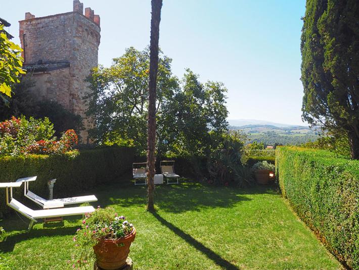 um jardim com um banco e um castelo em Sirena em Montefollonico