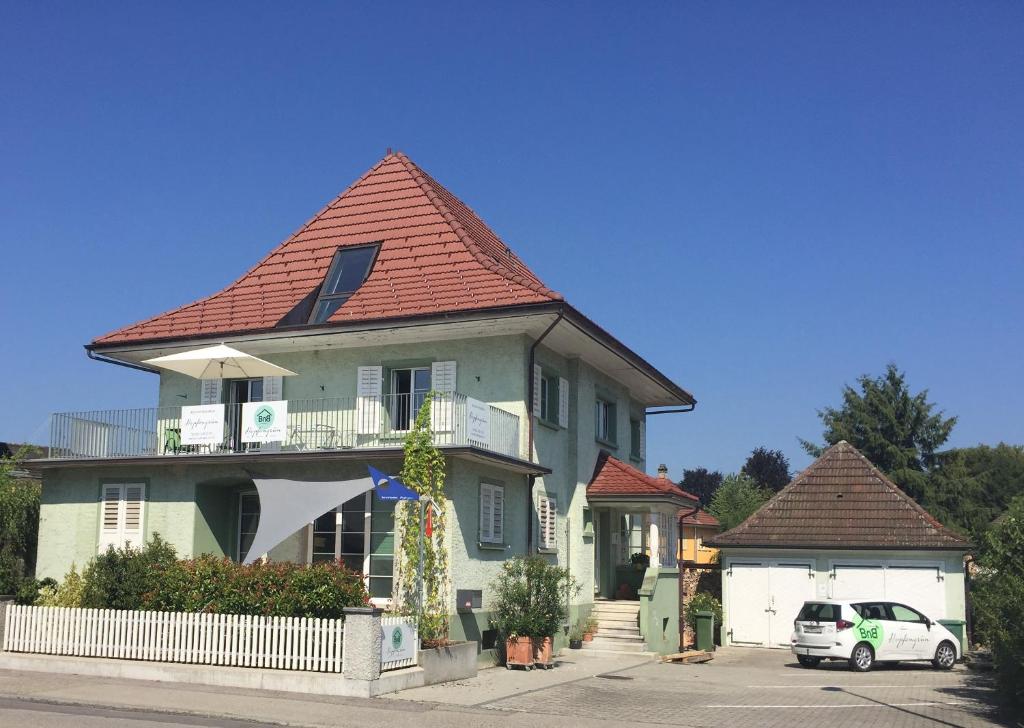 ein Haus mit einem davor geparkt in der Unterkunft BnB Hopfengrün Langenthal in Langenthal