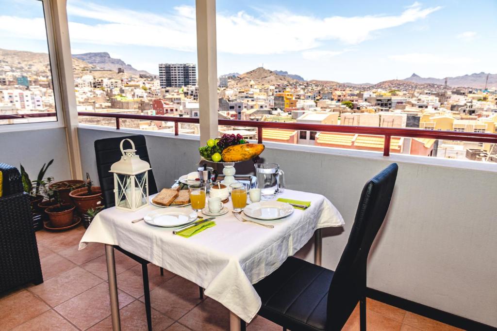 a table on a balcony with a view of a city at Criola Maison in Mindelo