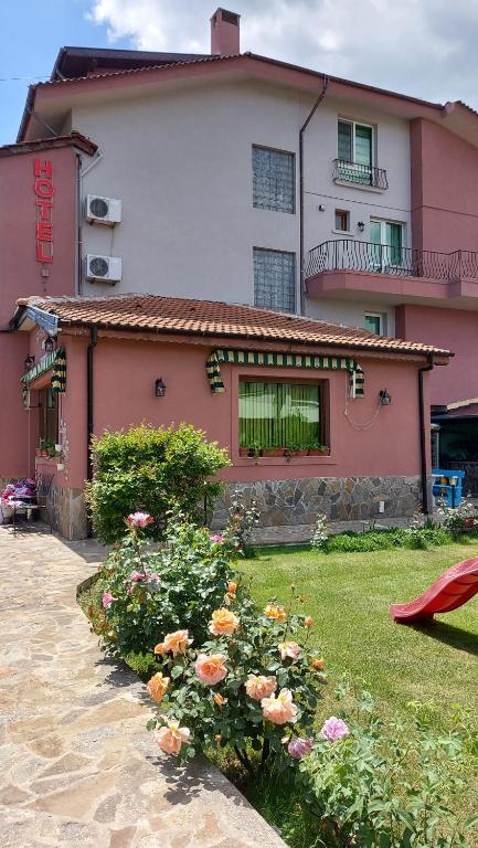 a house with a yard with flowers in front of it at Hotel Bon Relax in Ravadinovo