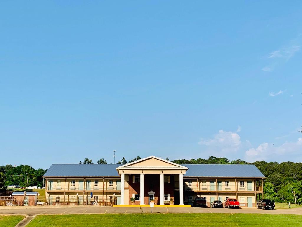 a large building with a parking lot in front of it at Weston Inn & Suites in Rusk