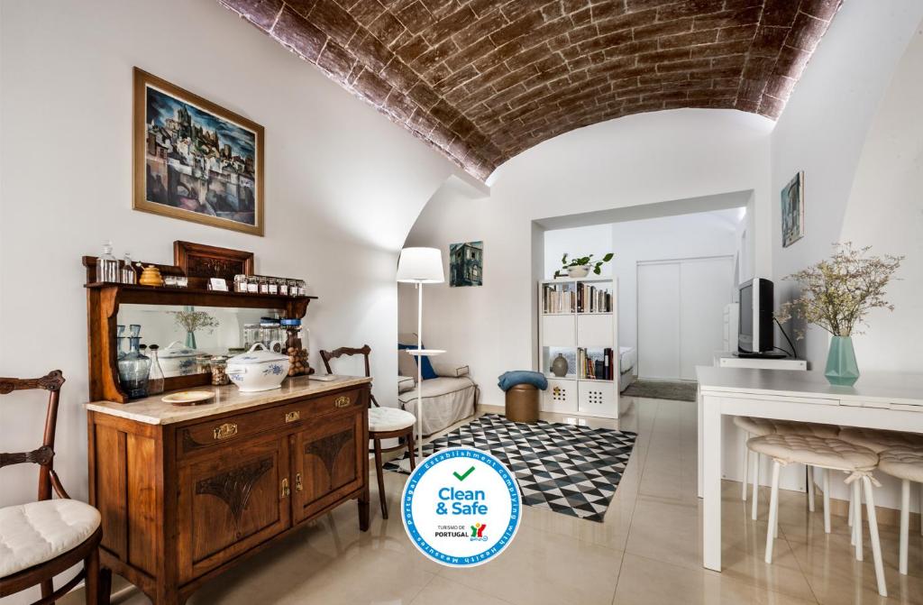 a living room with a table and a mirror at Ebora Home - free garage - Centro Histórico in Évora