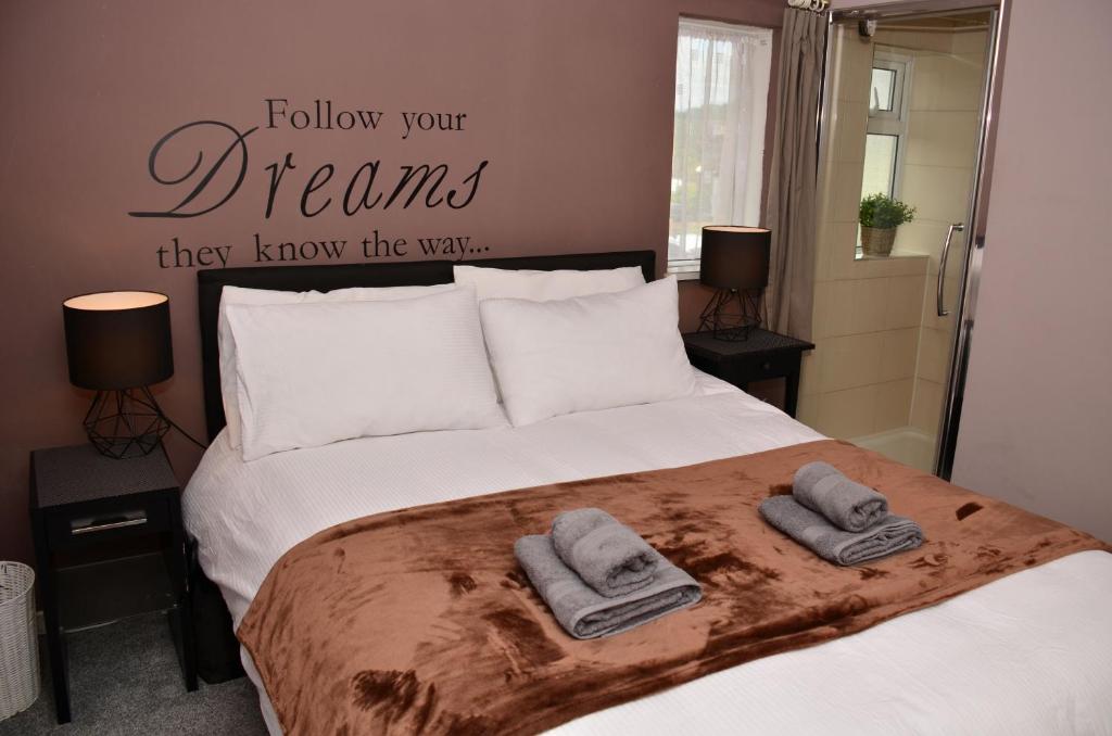 スタンウェルにある1FG Dreams Unlimited Serviced Accommodation- Staines - Heathrowのベッドルーム1室(ベッド1台、タオル2枚付)