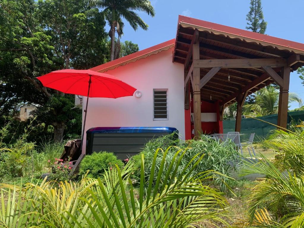 un paraguas rojo frente a una casa en Ô TI JACKO, en Le Gosier