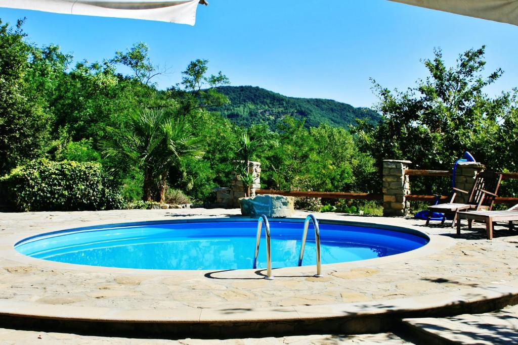 una piscina en un patio trasero con una mesa y una silla en 6 bedrooms villa with private pool furnished garden and wifi at Mombarcaro en Tetti