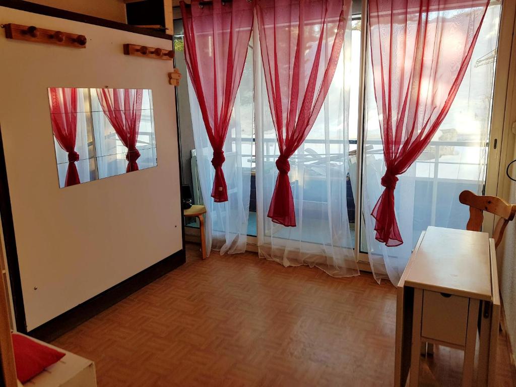 a room with red curtains and a large window at Studio avec balcon amenage et wifi a Vars in Vars
