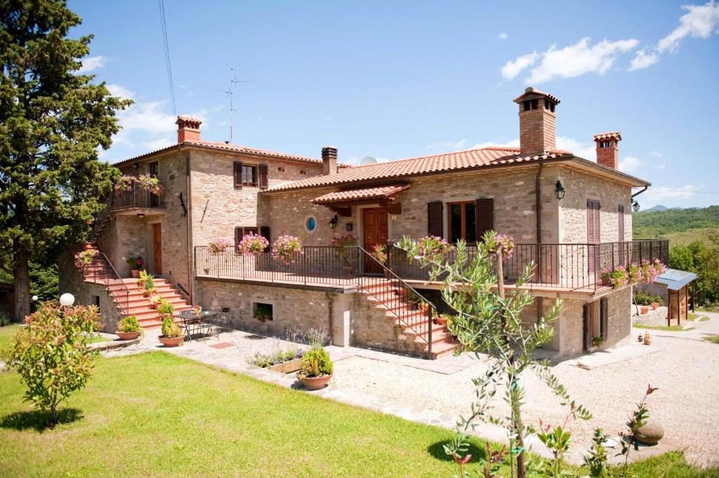 a large stone house with a staircase in a yard at 3 bedrooms appartement with shared pool enclosed garden and wifi at Caprese Michelangelo in Arezzo