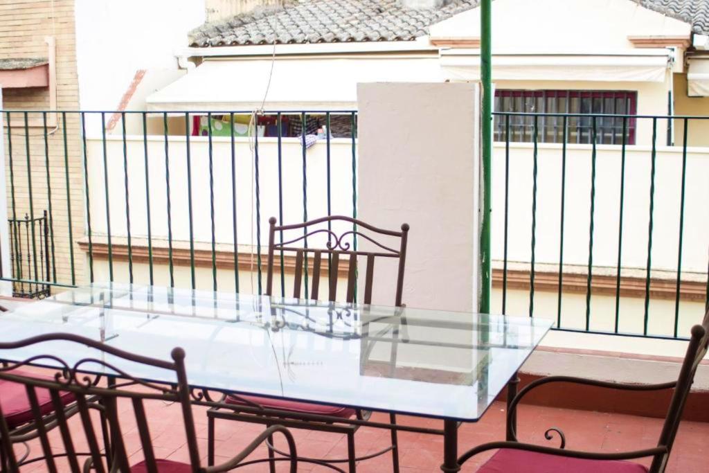 einen Glastisch und Stühle auf dem Balkon in der Unterkunft One bedroom apartement with city view terrace and wifi at Sevilla in Sevilla
