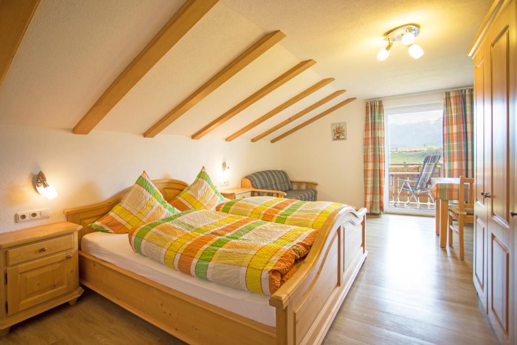 ein Schlafzimmer mit einem Bett mit gelben und grünen Decken in der Unterkunft Gästehaus Poppler in Hopferau