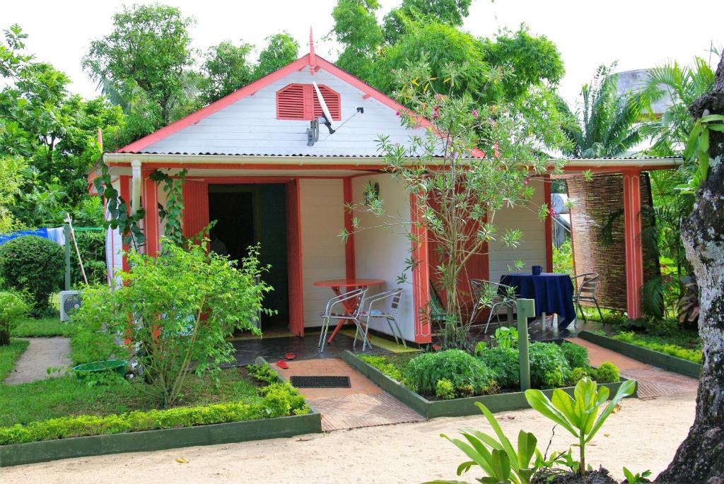un piccolo cottage rosso con tavolo e sedie in giardino di Studio with sea view enclosed garden and wifi at Foulpointe a Foulpointe