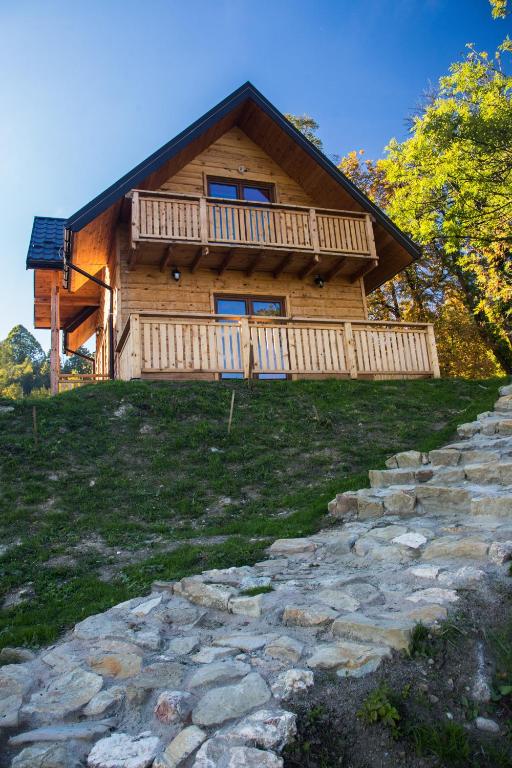 a log cabin with a stone path in front of it at Domki Na Ogrodach in Falsztyn