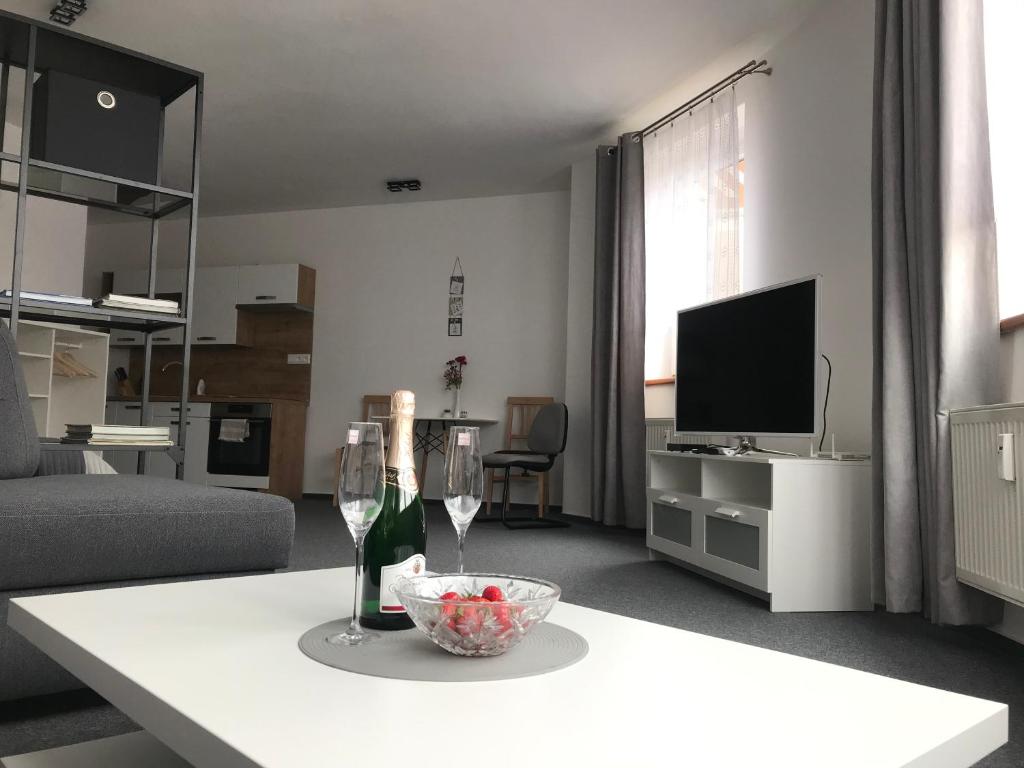 a living room with a table with a bottle of wine at Maja Apartmán č 4 in Bešeňová