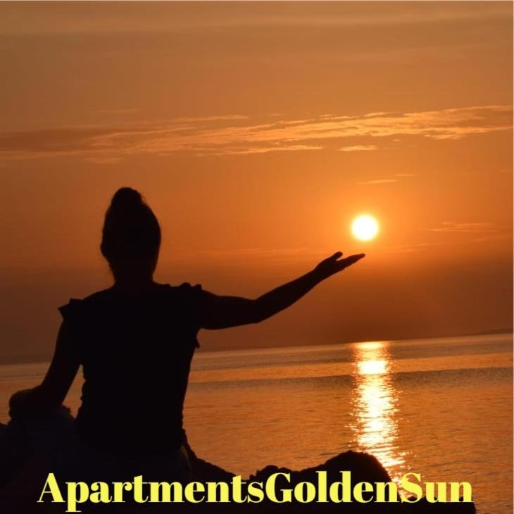 a person sitting on the beach looking at the sunset at Apartment Golden Sun in Vir