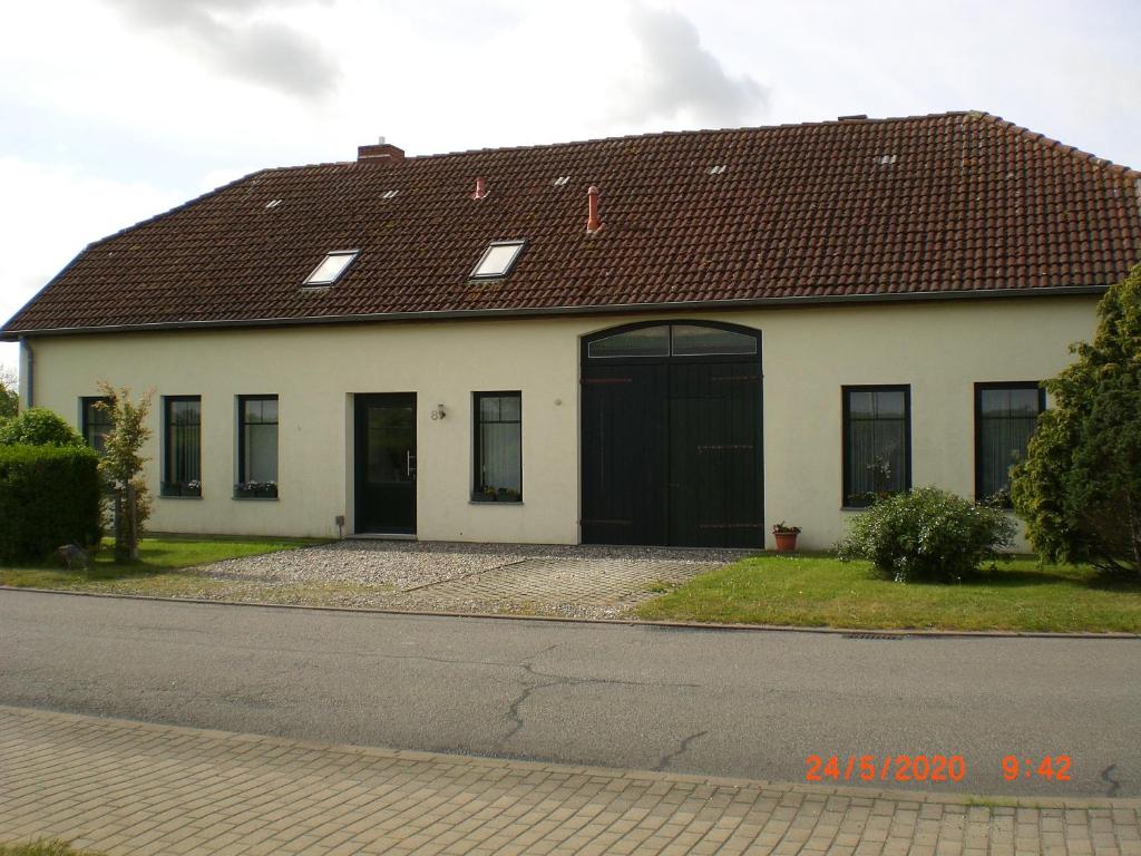 uma grande casa branca com um telhado preto em Ferienhaus Weitblick em Börgerende-Rethwisch