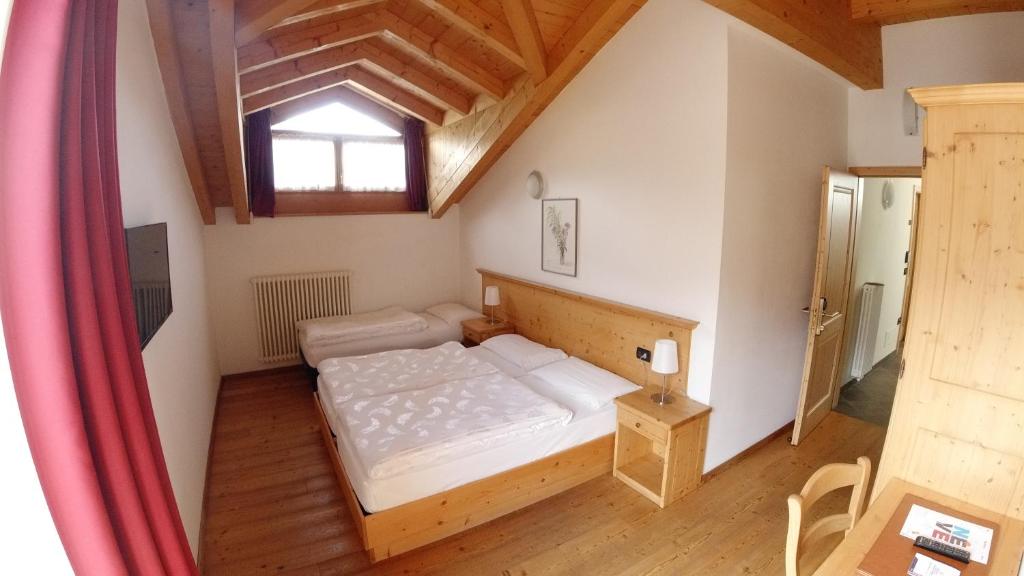 Habitación pequeña con cama y ventana en Camping Dolomiti, en Dimaro