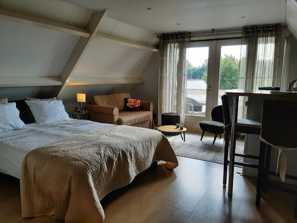 um quarto com uma cama e uma sala de estar em In de Wolken em Giessenburg