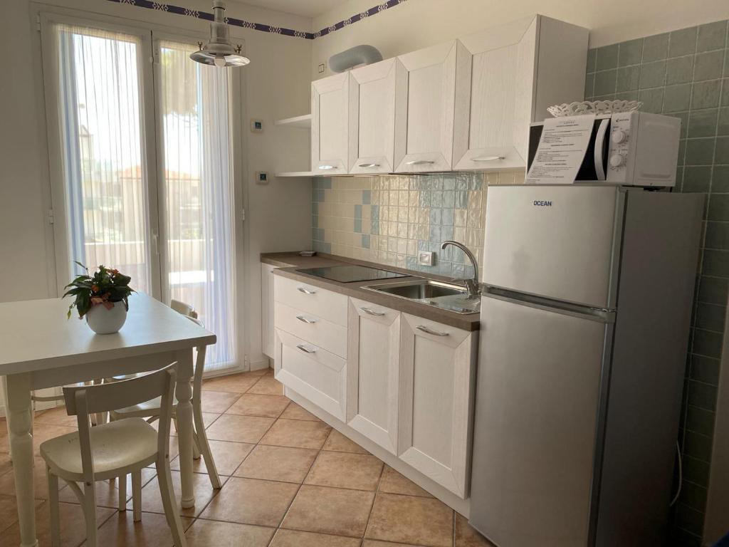 cocina con nevera blanca y fregadero en Residence Ambra, en Lido di Jesolo