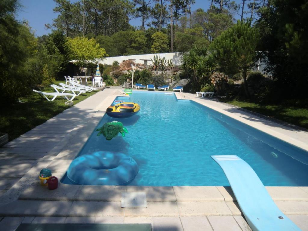 a large swimming pool with a raft and a boat in it at Seaside Villa in Pataias with Private Pool in Pataias