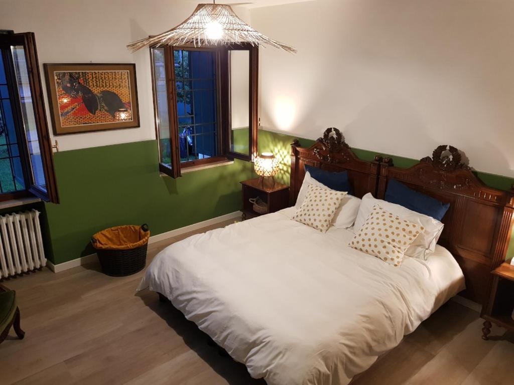 um quarto com uma cama branca e uma parede verde em RESIDENZE AI SALVI em Verona