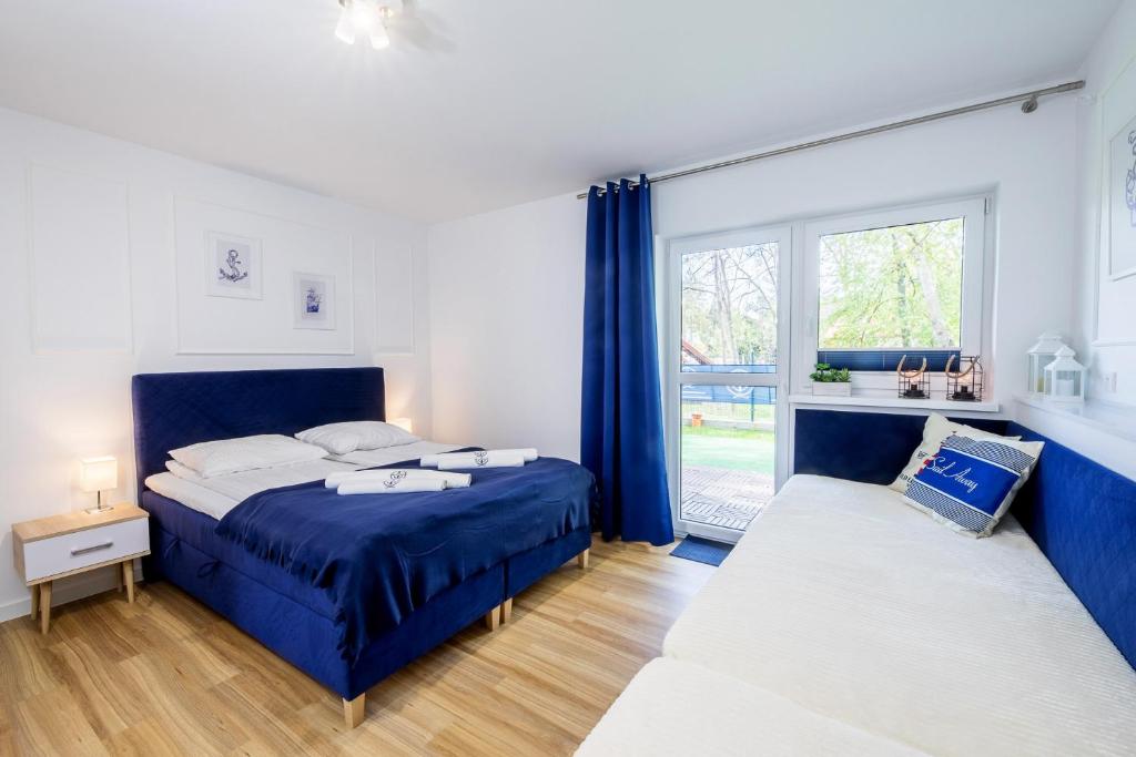 une chambre avec deux lits et une fenêtre dans l'établissement Apartament 3B Niebieskie Apartamenty z basenem krytym, odkrytym, salą zabaw, animacjami, à Poddąbie