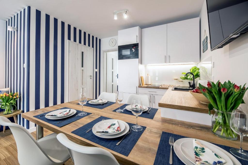 - une salle à manger et une cuisine avec une table et des chaises dans l'établissement Apartament 3B Blue Marine Poddąbie, à Poddąbie