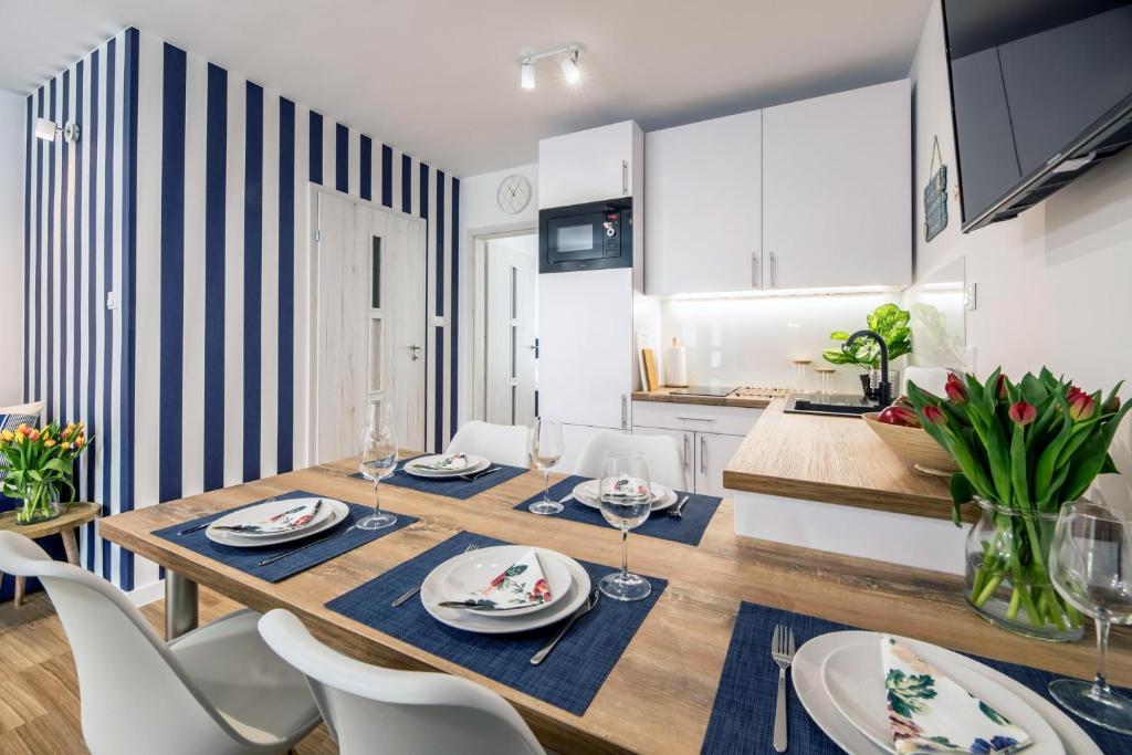 a dining room and kitchen with a table and chairs at Apartament 3B Blue Marine Poddąbie in Poddąbie