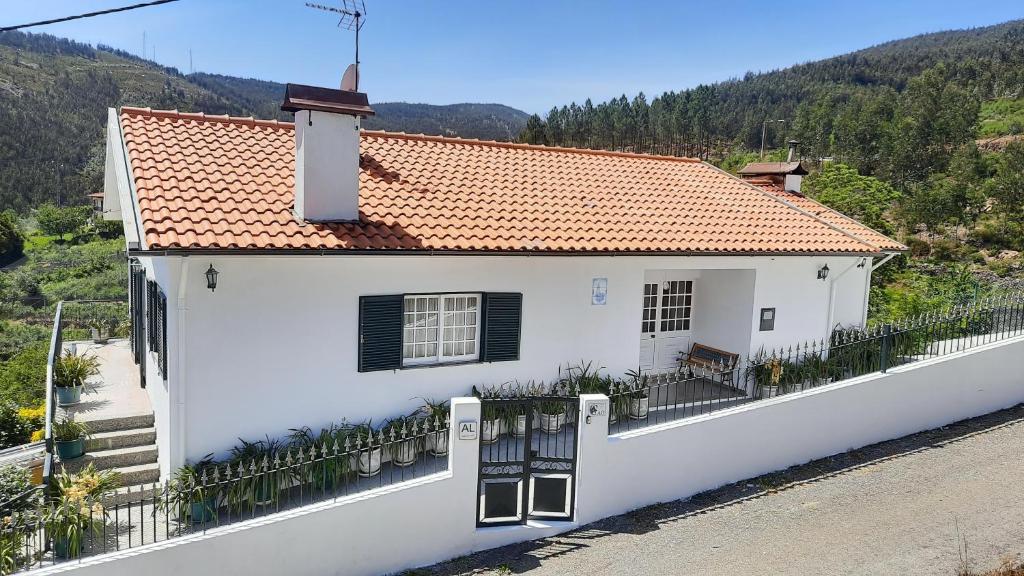 une maison blanche avec une clôture devant elle dans l'établissement Casa de Vilarinho, à Arouca