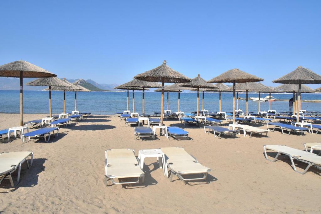 een strand met stoelen en parasols en de oceaan bij Marathona's Apartment in Aegina Town