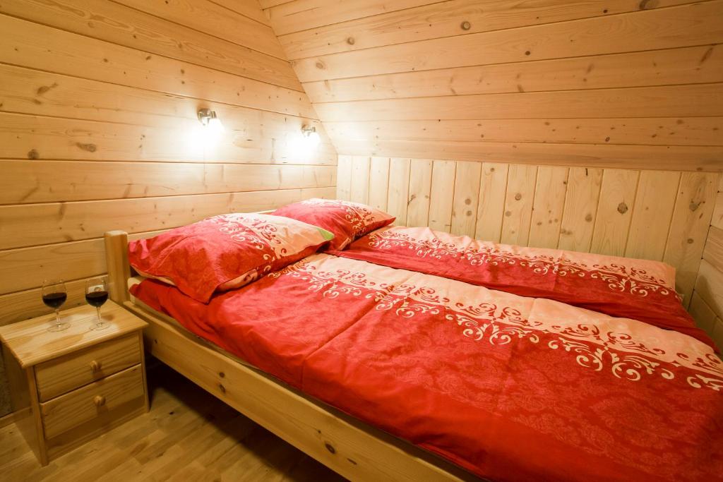 a bedroom with a bed in a log cabin at Domki Na Ogrodach in Falsztyn