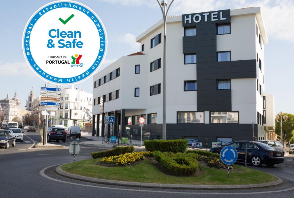 una señal de hotel frente a un edificio en Mafra Hotel, en Mafra