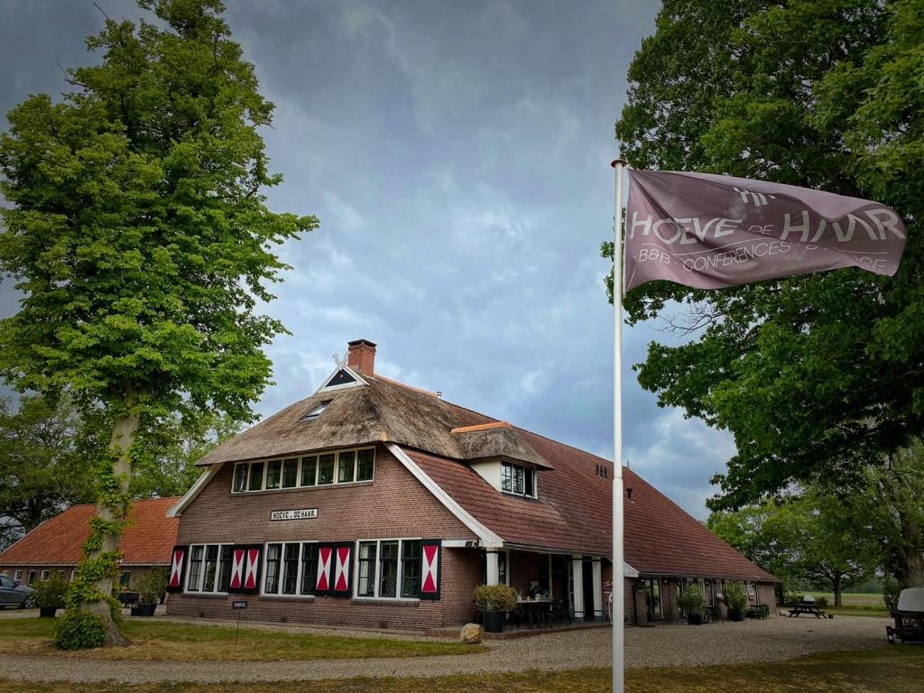 a house with a flag in front of it at Boutique B&B Hoeve de Haar in Delden
