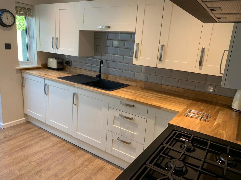 a kitchen with white cabinets and a counter top at Cottage in the heart of Montacute in Montacute