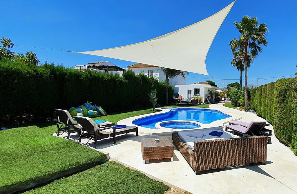 a backyard with a pool with chairs and a table at 142B Dehesa Baja in Alhaurín el Grande