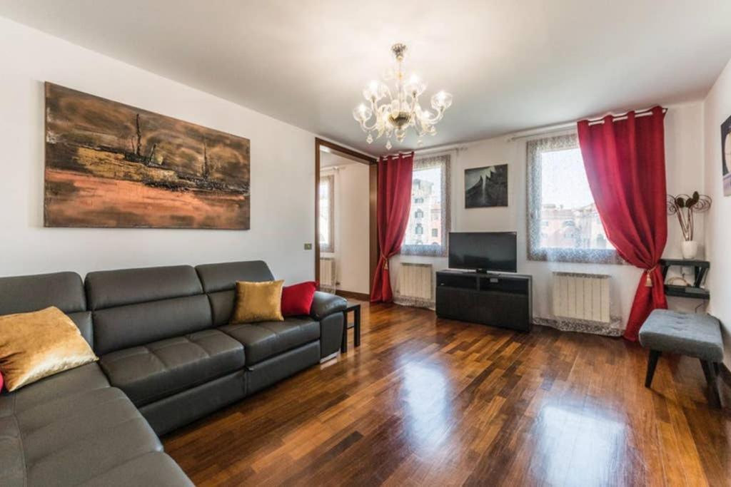 a living room with a couch and red curtains at Rialto apartment with Canal Grande view in Venice